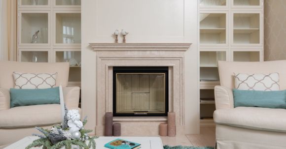 Luxury Properties - Interior of modern living room with armchairs on carpet near table next to marble pink fireplace