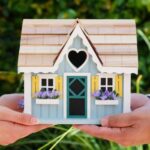 New Home - People Holding Miniature Wooden House