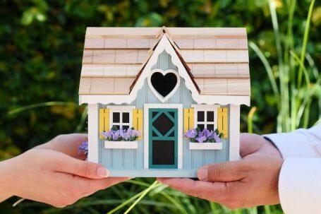 New Home - People Holding Miniature Wooden House