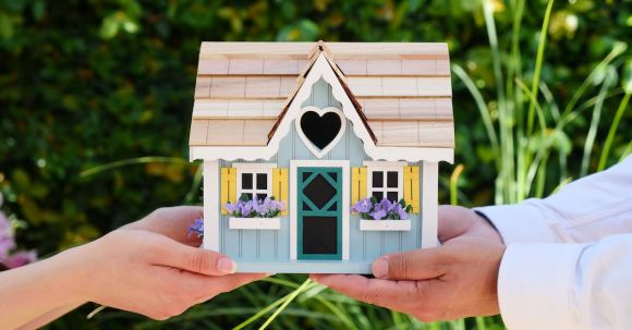 New Home - People Holding Miniature Wooden House