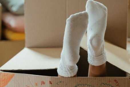 New Home - Person in White Socks Standing on Brown Cardboard Box