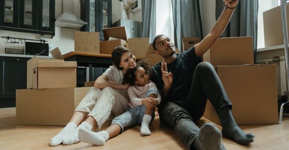 New Home - Woman in Black Shirt and Black Pants Sitting on Brown Sofa Chair