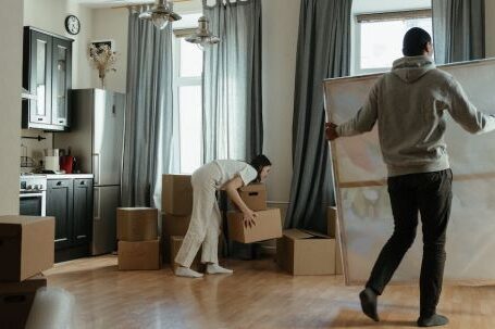 New Home - Man in Gray Hoodie Standing Near White Window Curtain