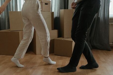 New Home - Man in White T-shirt and Black Pants Holding Woman in White T-shirt